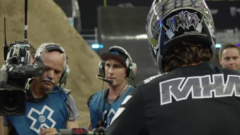 X-Games-Kameramann-Schießt-Übertragung-Von-Motocross-Dirtbike-Fahrern,-Die-Sich-Auf-Den-Wettbewerb-Vorbereiten,-Rote-4K-Zeitlupenkamera
