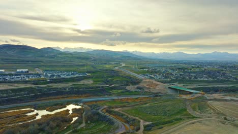 Luftaufnahme---Atemberaubende-Aussicht-Auf-Den-Sonnenuntergang-In-Der-Nähe-Der-Eisenbahn-Und-Des-Jordan-River-In-Bluffdale,-Utah,-Vorwärts--Und-Abstiegsaufnahme