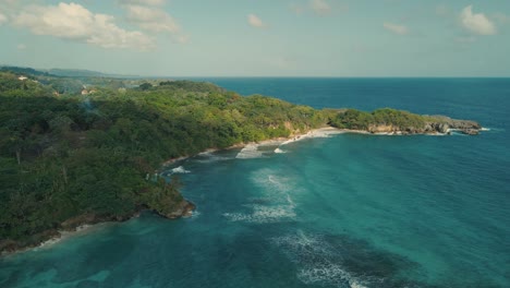 Drone-shot-of-hills-and-sea-with-waves-crashing-on-reefs-on-the-coast-line