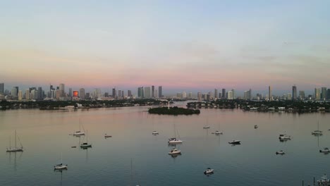 Colorful-Vibrant-Sky-over-Miami,-Florida-City-Skyline-with-boats-in-Harbor---Time-Lapse