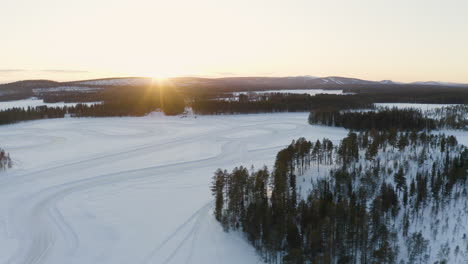 Luftaufnahme-über-Die-Idyllische,-Schneebedeckte-Bewaldete-Polarwildnis-Von-Norrbotten,-Schweden,-Lappland-Bei-Sonnenaufgang