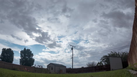 Cloudscape-and-rain-shower-above-a-suburban-neighborhood-in-a-typical-backyard---time-lapse