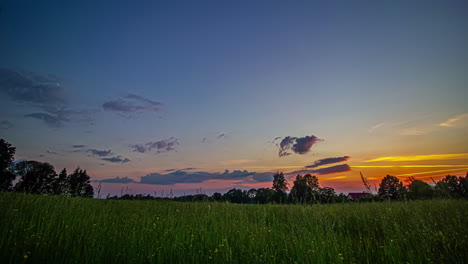 Zeitrafferaufnahme-Wunderschöner-Grüner-Wiesen-Bei-Sonnenuntergang-Vor-Einem-Ferienhaus-In-Der-Abenddämmerung