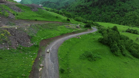 Car-Driving-On-Dirt-Road-In-A-Hillside-Near-Ushguli-Village-In-Georgia---aerial-shot