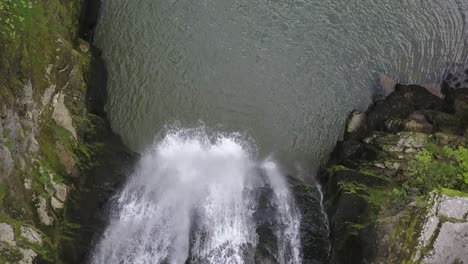 Drohnenansicht-Von-Oben-Auf-Einen-Riesigen-Wasserfall-Mit-Felsen-Und-Einem-See,-Fluss-Doubs,-Neuchâtel,-Schweiz