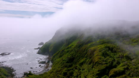 Luftaufnahme-Entlang-Der-Insel-Chiloe-Mit-Wolken,-Die-über-Der-Küste-Aufsteigen