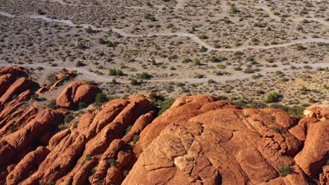 Aerial-view-overlooking-details-of-erosion-on-red-sandstone-cliffs-in-sunny-USA---pan,-drone-shot