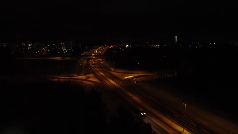 Luftaufnahme:-Fahrzeug-Verlässt-Die-Geteilte-Autobahn-In-Der-Winternacht-In-Der-Nähe-Von-Helsinki