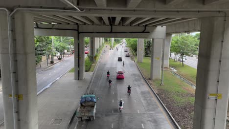 Bangkok-car-and-motorbikes-traffic-on-road-under-elevated-skytrain-tracks