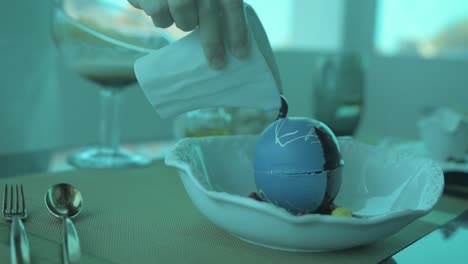 Melting-a-souffle-ball-with-hot-chocolate,-in-a-under-water-restaurant-in-the-Maldives