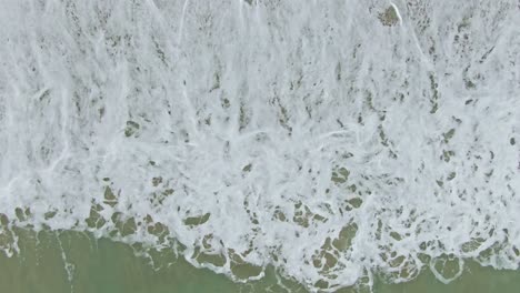 Fesselnder,-Entspannender-Blick-Auf-Starke-Meereswellen,-Die-In-Richtung-Des-Strandsandes-Plätschern-Und-Schaumige-Blasen-Bilden