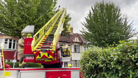 A-London-Fire-Brigade-turntable-aerial-ladder-firetruck-attends-the-scene-of-a-house-on-a-residential-road