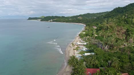 Nice-aerial-view-of-beautiful-beaches,-natural-view-of-the-nature-seascape,-calm-sea,-cloudy-sky,-tall-green-mountains-from-the-Island-of-Puerto-Galera,-Philippines