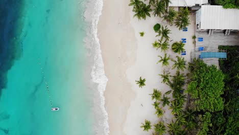 FLYING-DRONE-IN-ROATAN-BEACH-WITH-CRYSTAL-CLEAR-BLUE-WATER