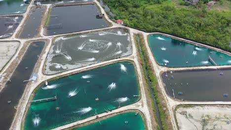Birds-eye-view-overlooking-at-the-controlled-environment-of-aquaculture-industry,-fish-farms-with-aerator-pump-oxygenation-water,-food-supply-production,-manjung-perak-malaysia,-southeast-asia