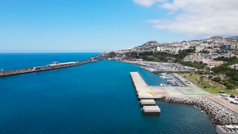 Drone-aerial-pan-right-view-of-Atlantic-Ocean-and-the-harbor-in-Funchal-city,-Madeira-island-in-Portugal