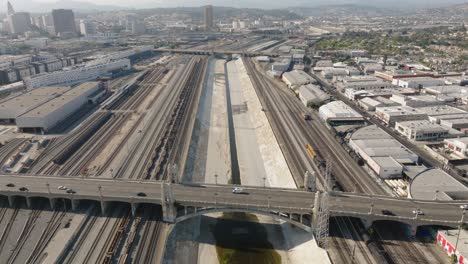 Flying-Above-Sixth-Street-Bridge,-Also-Known-as-Ribbon-of-Light,-in-Downtown-Los-Angeles-Boyle-Heights-Area,-Drone-Above-Roads-and-Train-Track