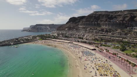 People-suntanning-and-enjoying-Playa-De-Amadores-sand-beach,-Gran-Canaria,-Canary-Islands,-Spain