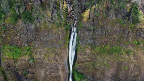 Drone-shot-revealing-a-tall-waterfall-cascading-over-the-cliffside-in-the-Columbia-River-Gorge-in-Oregon