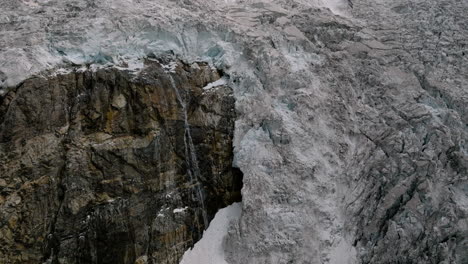 Water-Flowing-From-Edge-Of-Adishi-Glacier-In-Caucasus-Mountain---aerial-shot
