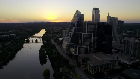 Beautiful-sunset-behind-the-Colorado-river-and-Austin-skyscrapers-in-USA---Aerial-view