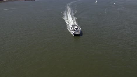 Aerial-view-over-a-ferry-on-Hudson-river,-in-sunny-New-York,-USA---tilt,-drone-shot