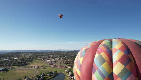 Drone-Shot-of-Hot-Air-Balloons-Flying-Above-Lake-and-Landscape-of-Colorado-USA