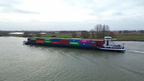 Mondscheinfrachtschiff,-Beladen-Mit-Intermodalen-Containern,-Das-Im-Fluss-Merwede-In-Der-Nähe-Von-Hardinxveld-Giessendam-In-Den-Niederlanden-Fährt