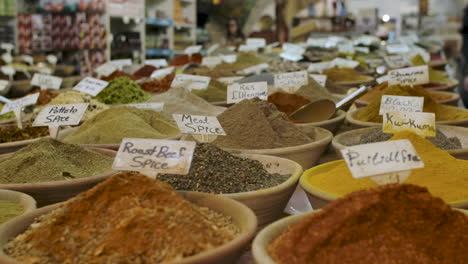 Many-different-spices-for-sale-inside-bowls-at-a-local-shop,-each-for-a-specific-dish