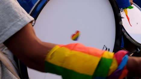 Person-playing-a-drum-in-a-marching-band-during-PRIDE-2022-with-a-rainbow-heart-in-Dili,-Timor-Leste,-Southeast-Asia,-closeup-of-drum,-heart-and-rainbow-symbol