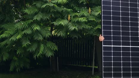 Affordable-solar-panels-for-renewable-energy-at-home,-person-bringing-panel-across-frame