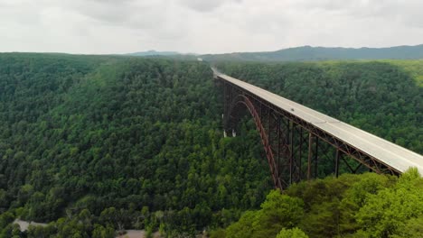 Parallax-aerial-drone-shot-over-trees-of-New-River-Gorge-Bridge-in-Fayetteville,-WV