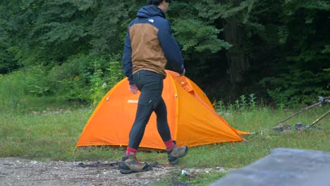 Hombre-Desmontando-Carpa-En-Un-Camping-4k