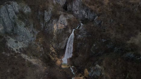 Cascada-De-Skakavica-Que-Fluye-Hacia-Abajo-En-La-Ladera-De-Una-Montaña-Rocosa,-Albania
