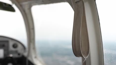 Closeup-of-grab-handle-strap-on-board-of-small-private-airplane,-handheld