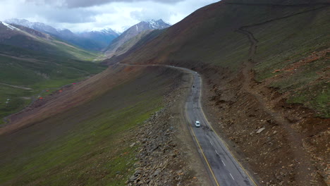 Cinematic-drone-shot-of-the-Babusar-pass-in-Pakistan,-with-a-few-vehicles-on-the-road-in-the-Kaghan-Valley