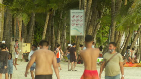 Tourists-walk-around-and-enjoy-the-white-sand-beaches-of-Boracay-in-the-Philippines
