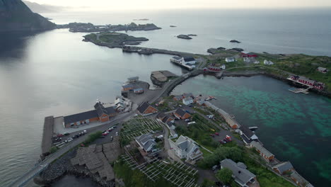 Aerial-backwards-shot-of-the-famous-fishing-village-near-reine-in-Lofoten-with-scenic-bridges-during-midnight-sun