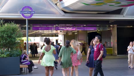 Canary-Wharf,-London,-United-Kingdom---August-2022---A-group-of-young-women-are-walking-towards-the-entrance-of-the-new-Elizabeth-Line-in-Canary-Wharf-during-a-sunny-summer-afternoon
