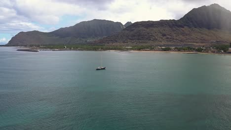 Aerial-view-of-lone-sailboat-in-Pokai-bay-Waianae-Oahu-on-a-calm-day