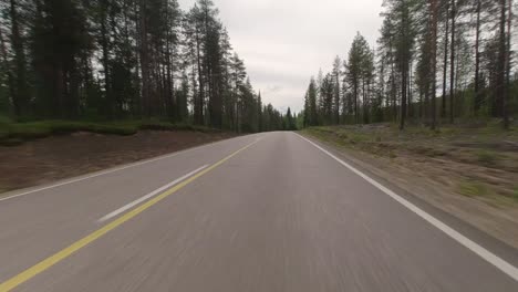 Driving-on-narrow-forest-road-in-lapland-with-passing-cars
