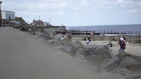 Wide-shot-of-Hornsea-town-beach-in-England-with-people-walking-about