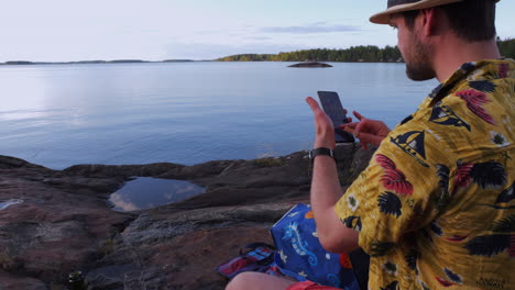 Vacation-man-using-mobile-smartphone,-over-the-shoulder-view