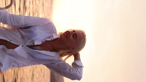 Portrait-of-a-blonde-woman-in-a-white-shirt-posing-on-a-sailboat-in-the-Adriatic-Sea-during-sunset-in-Dubrovnik,-Croatia