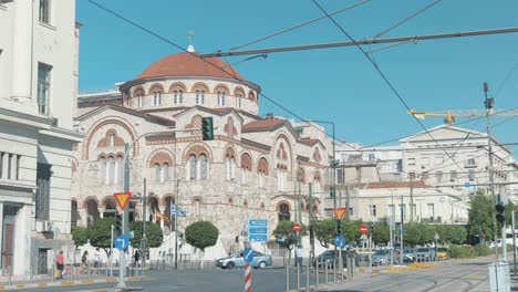 Los-Peatones-Pasan-Frente-A-La-Catedral-De-La-Santísima-Trinidad-En-El-Pireo,-Grecia
