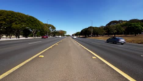 View-from-the-middle-of-a-four-lane-road-with-vehicular-traffic-on-both-sides-in-Brasilia,-Brazil