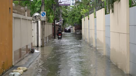 Un-Motociclista-Recorre-Las-Calles-Inundadas-De-Bangkok,-Tailandia