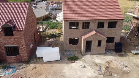 Traversing-left-to-right-view-of-new-build-houses-under-construction-on-a-building-site