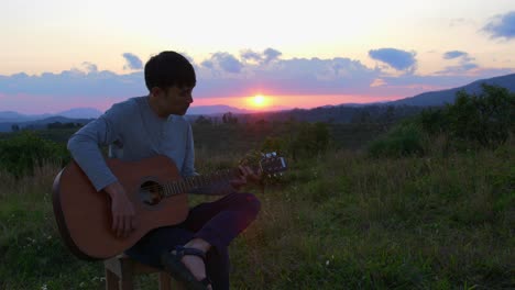Musiker-Tritt-Mit-Akustikgitarre-Bei-Sonnenuntergang-Und-Horizont-Im-Hintergrund-Auf,-Vietnam