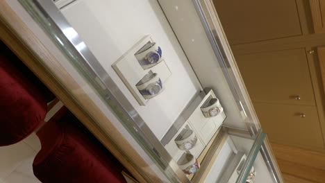 Vertikale-Aufnahme-Luxuriöser-Chopard-Uhren,-Die-In-Der-Glasvitrine-Des-Ladens-Ausgestellt-Sind